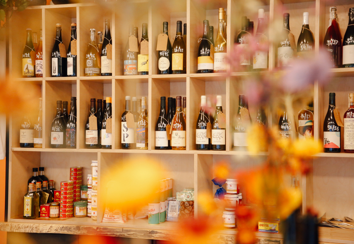 Wooden shelving filled with bottles of wine and spirits.