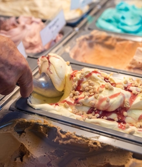 Rows of tubs of different flavour ice creams.