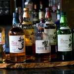 A row of bottles on a bar with Japanese text on them.