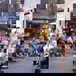 The courtyard at Yellow Arch filled with people standing and sitting at tables.