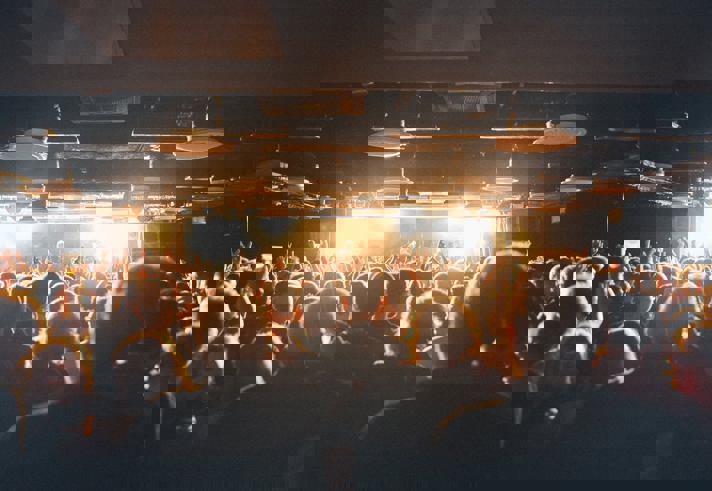 A crowd of people watching a band playing live.