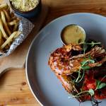 Prawns on a plate with a bowl of french fries at Butcher & Catch.