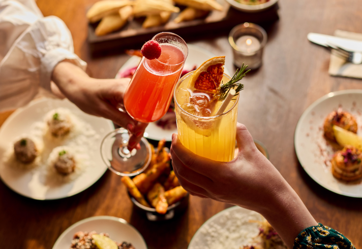 Two people dining at Cosy Club, and enjoying their cocktails.